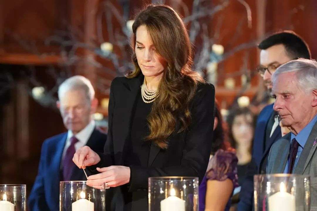 Britain's Catherine, Princess of Wales (C) lights a candle as a symbol to remember all those who lost their lives in the Holocaust and other genocides during a ceremony to commemorate Holocaust Memorial Day and the 80th anniversary of the liberation of Auschwitz-Birkenau at the Guildhall in London on January 27, 2025.
