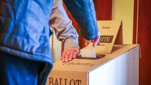 Someone submits their ballot in the federal election.