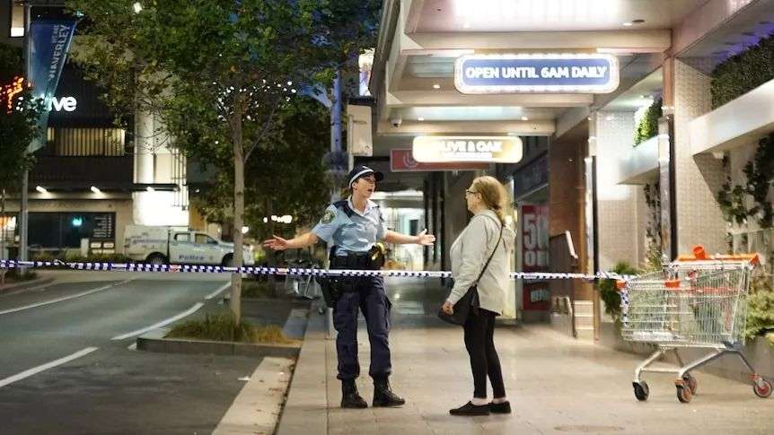 Police officer speaks to woman on empty street
