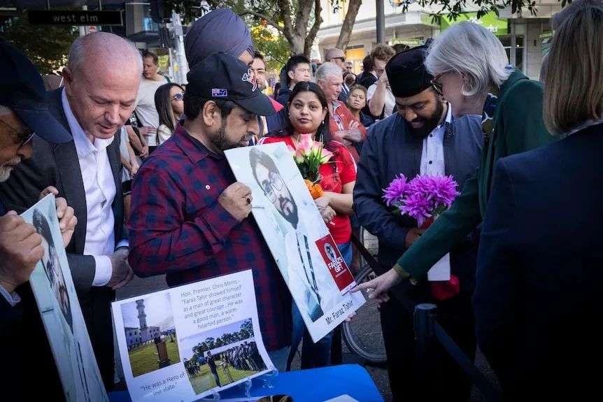 loved ones of killed security guard Faraz Tahir hold his picture at the commemoration of bondi stabbing attack