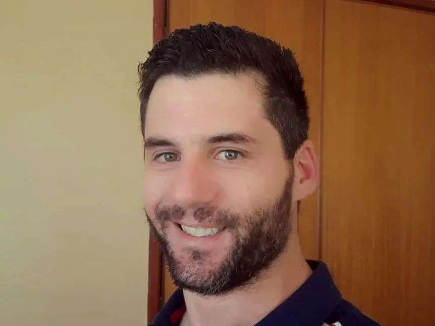 A bearded man smiles at the camera.