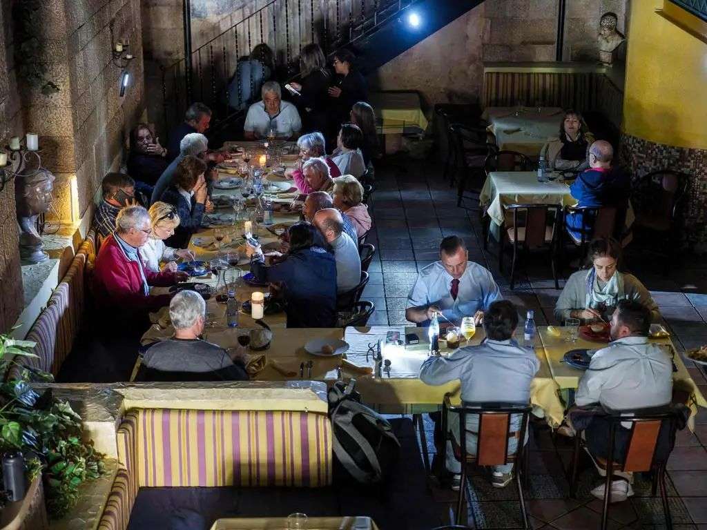 Customers eat in a restaurant with candles on tables in Burgos. Picture: AFP