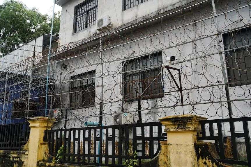 Barbed wire fences are seen outside a shuttered compound.