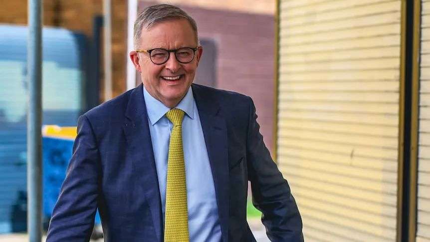 Opposition leader Anthony Albanese smiles walking along.