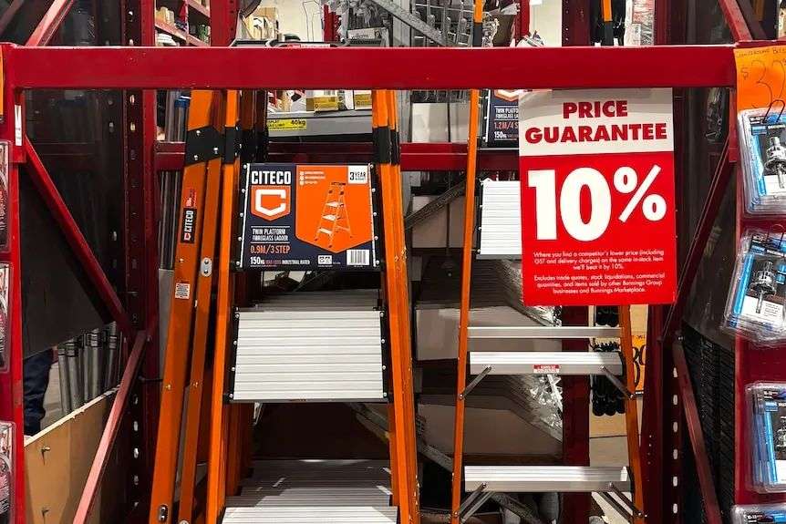 Citeco ladders in a Bunnings store. In front of them is a sign advertising Bunnings' 10 per cent price guarantee.