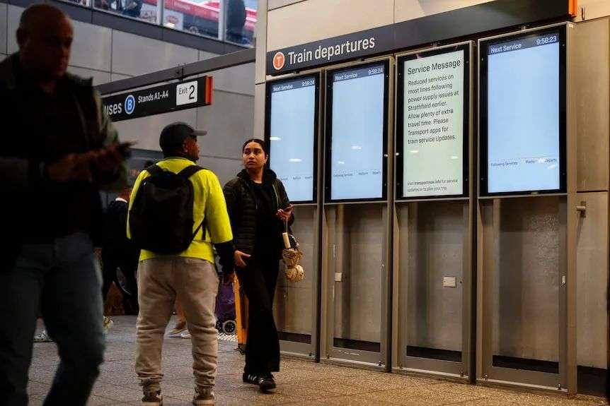 People look at blank screens at Parramatta Station