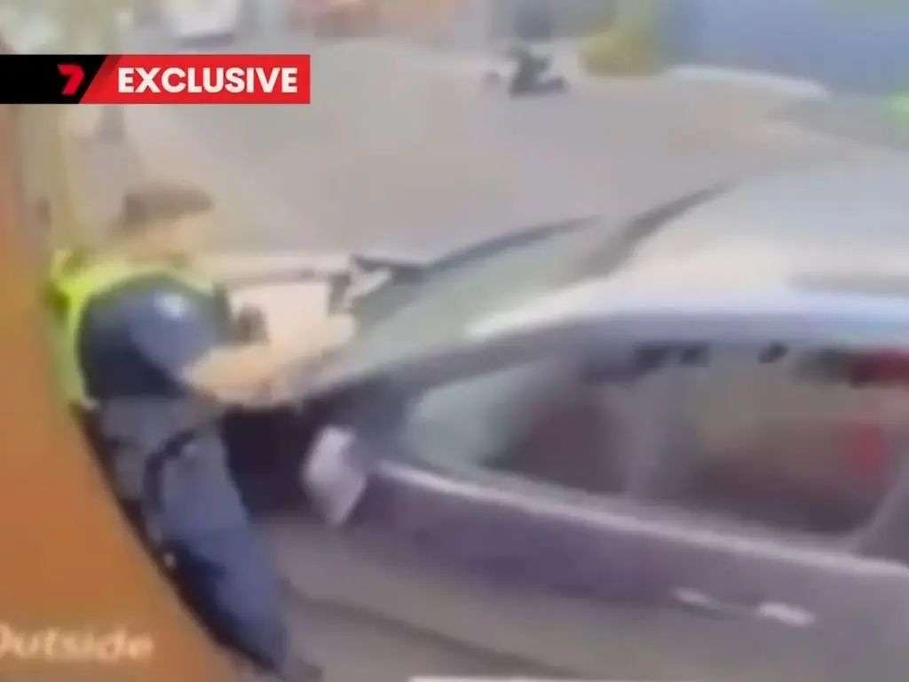 警察被汽车压在墙上的画面。图片来源：7频道