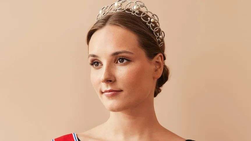 Princess Ingrid Alexandra wearing a crown, red sash and medals
