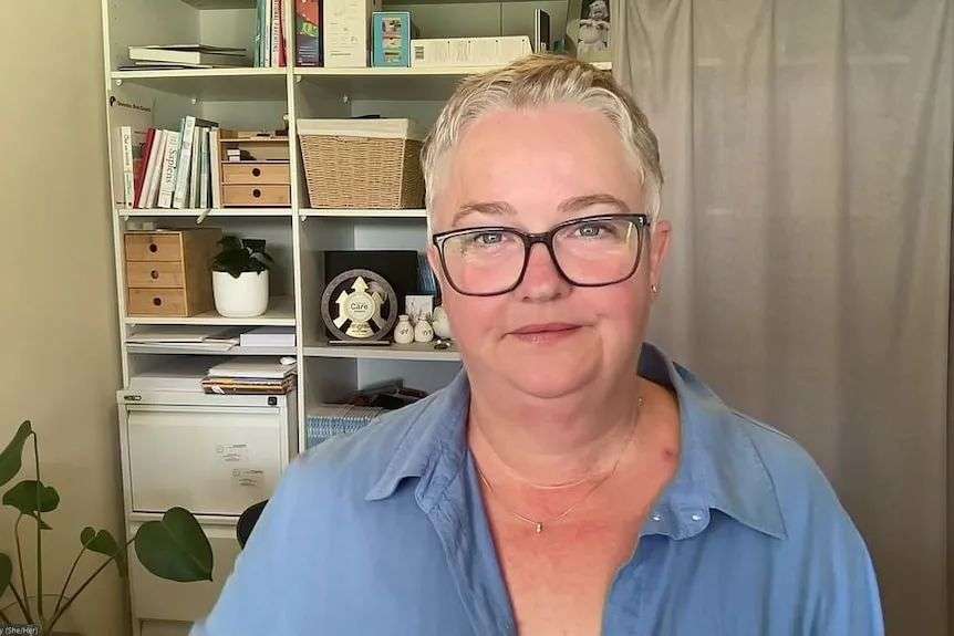 A woman with short hair, wearing glasses.