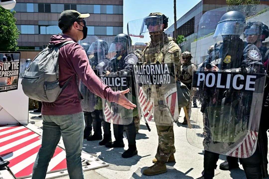 周二，抗议者在洛杉矶联邦大厦外与加州国民警卫队成员对峙。