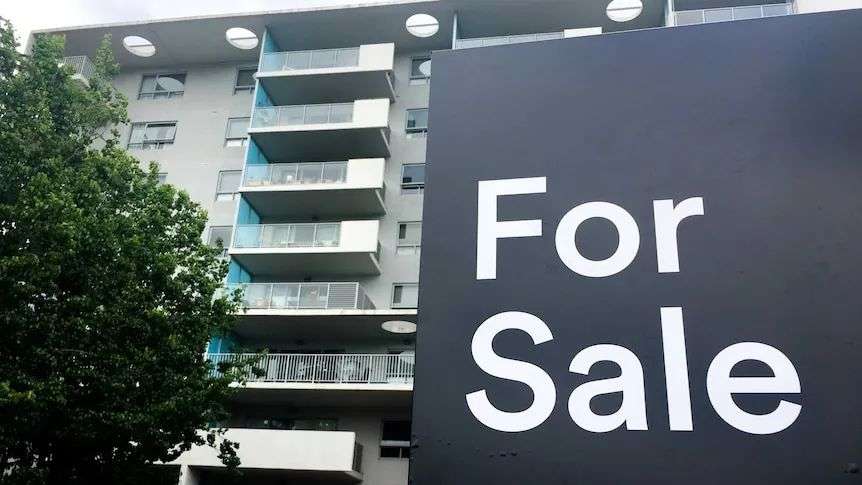 For sale sign in front of apartment building