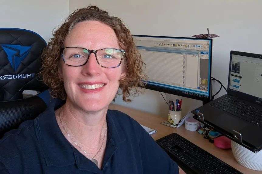 a woman at her desk smiles at the camera