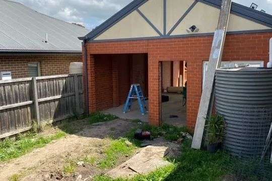 a brick garage with open doors showing building occurring inside