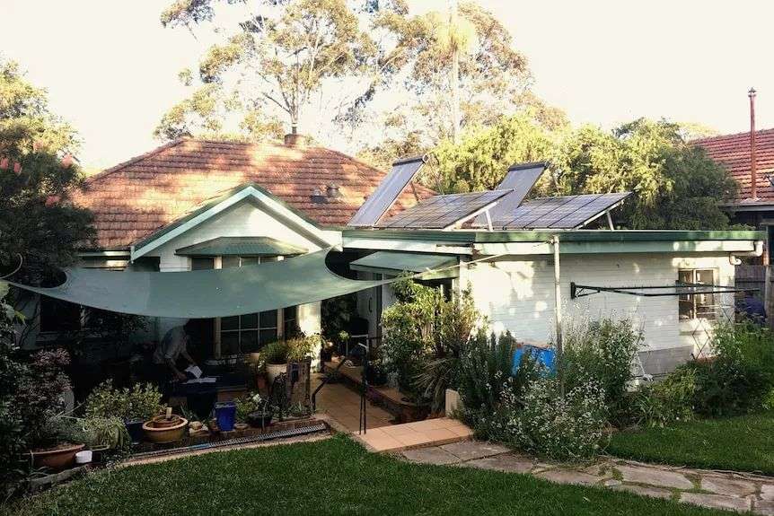 A suburban brick house with a leafy backyard