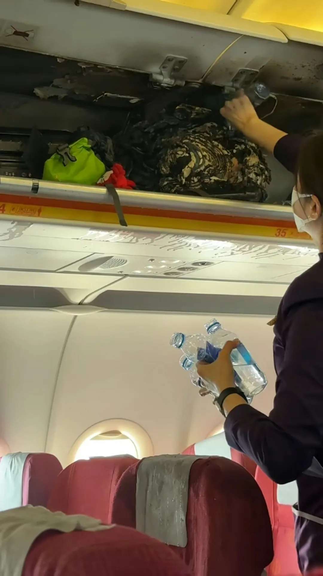 乘客及空姐不斷向行李艙倒水滅火。（影片截圖）