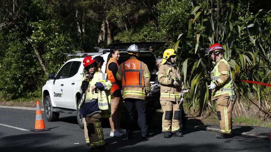 新西兰消防和紧急救援部门和奥克兰市议会工作人员正在Muriwai一处房屋后方发生山体滑坡的现场。图片/Hayden Woodward
