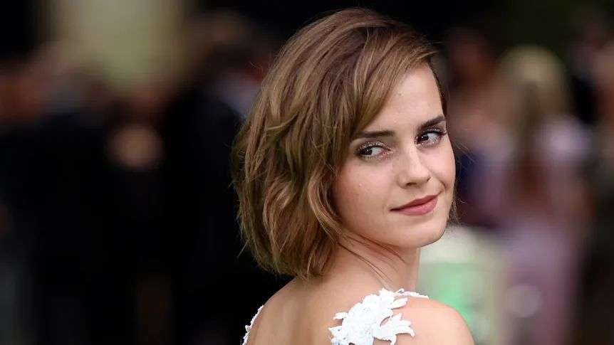 A close up of a woman with a white dress and pixie cut