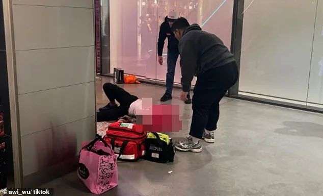 A witness shared a photo of paramedics treating the man as he lay on the ground (pictured)