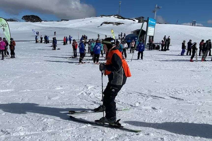 An elderly man skis on a flat section of snow