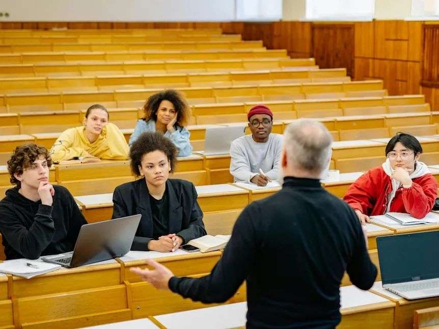 A man talking to a group of students in a lecture hall