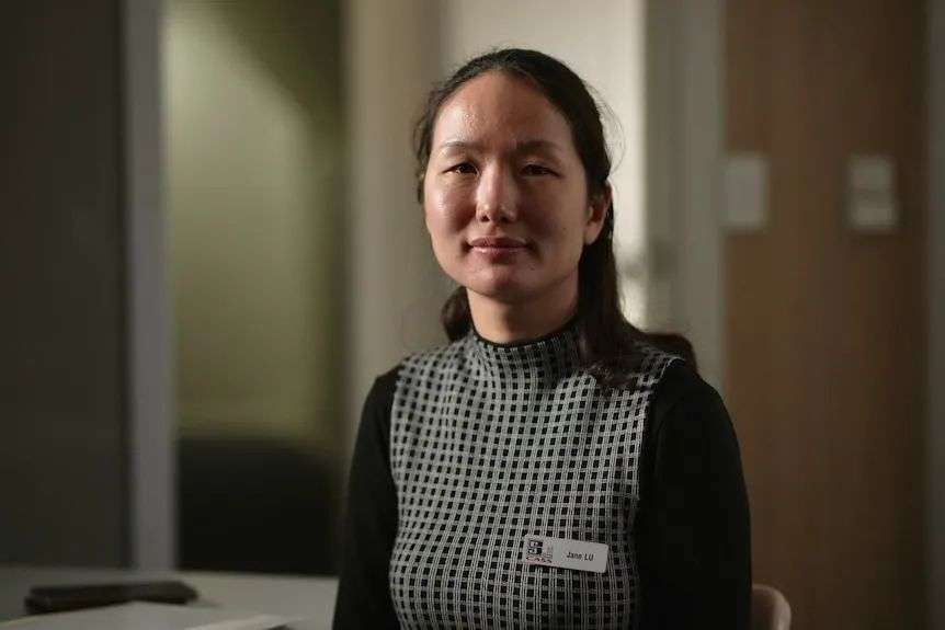 一名身穿深色连衣裙、齐肩长发的亚洲女性。