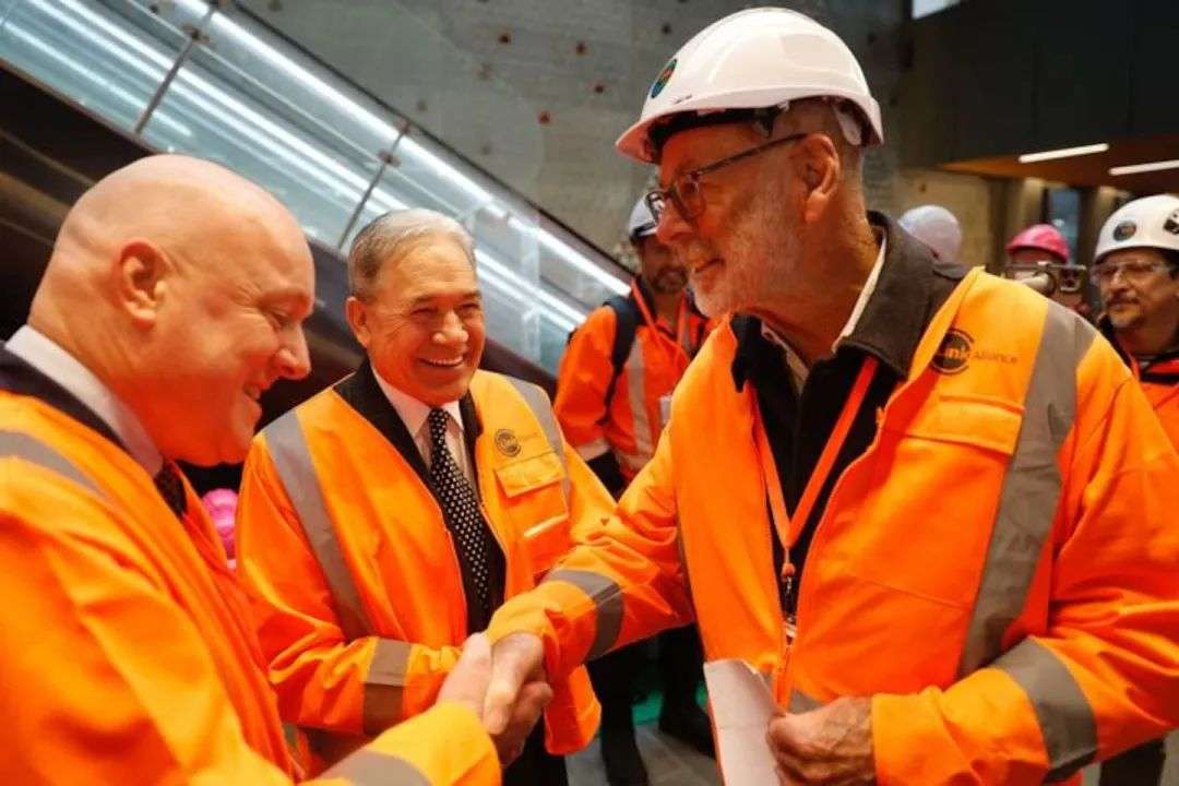 新西兰总理克里斯托弗·卢克森(左)、新西兰优先党领袖温斯顿·彼得斯(中)和奥克兰市长韦恩·布朗在今天上午历史性的城市铁路线列车上互相问候。图片/迈克尔·克雷格