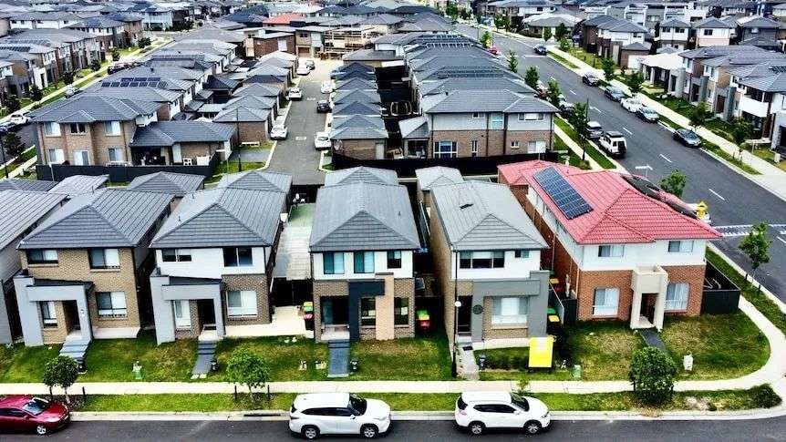 空中拍摄的郊区新住宅区内排列整齐的数十栋房屋。