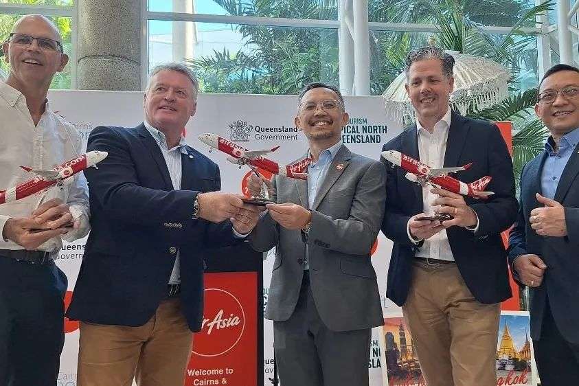Five men holding AirAsia model planes.