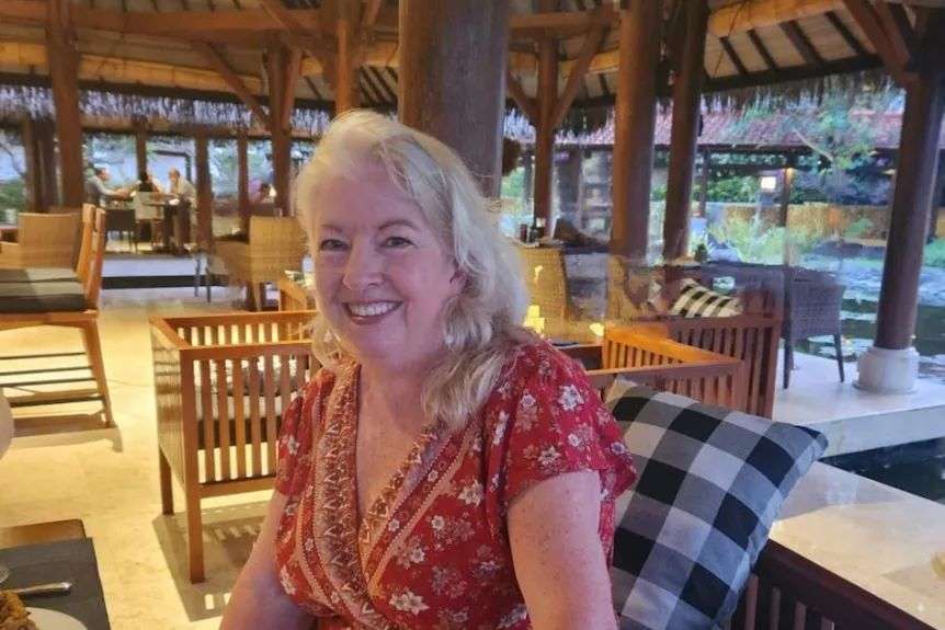 A woman sits under a hut in Bali.