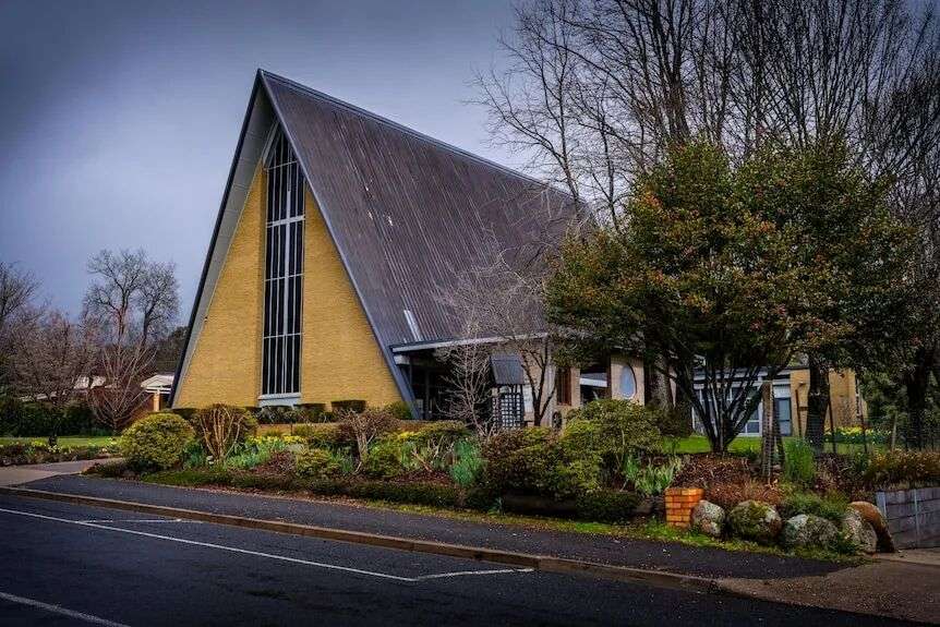 一座带有圆锥形屋顶的黄色教堂