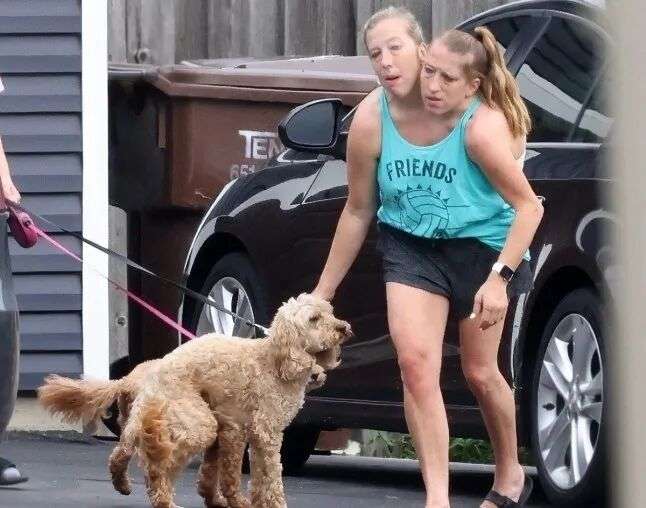 艾比和布列塔尼穿着黄色衬衫,牵着一条狗