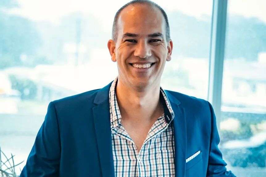 A man in a suit smiling for the camera