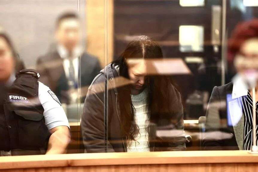 A woman sits with her head down