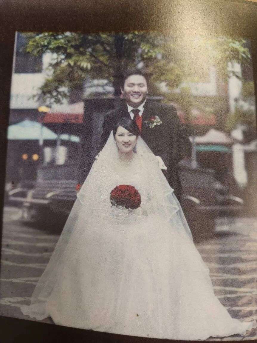 A photo of Hakyung Lee in a wedding dress and Ian Jo in a suit.