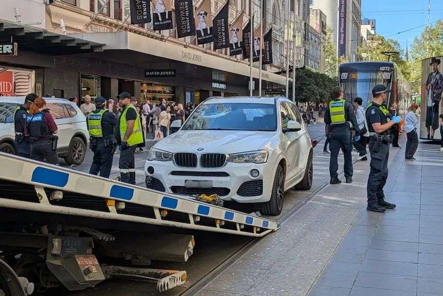 A white BMW being towed away in Bourke Street Mall, Melbourne