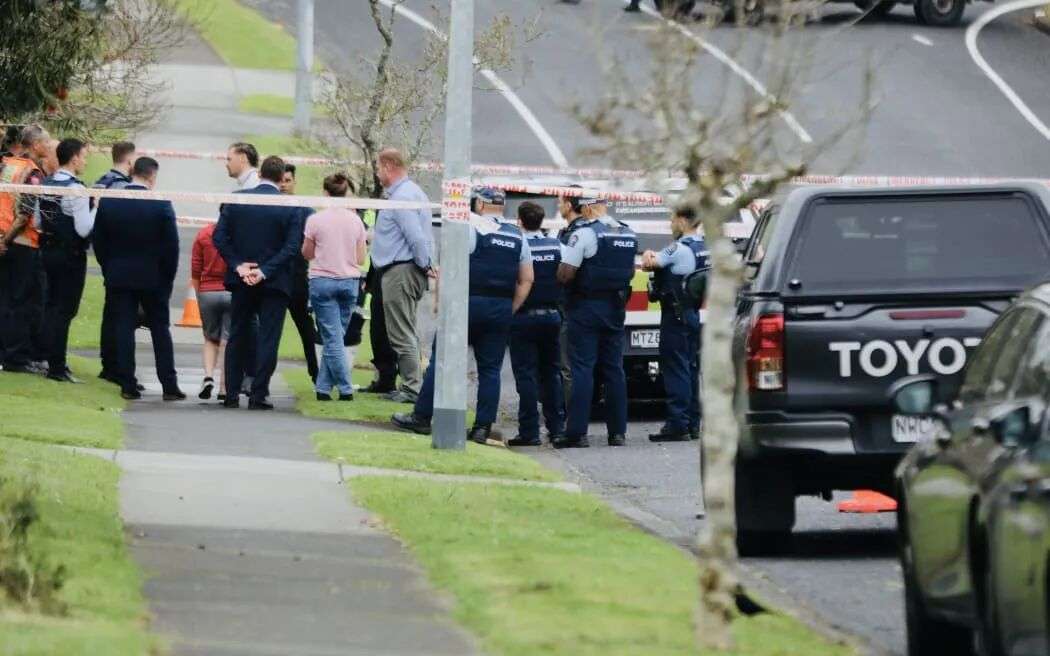 人们在 Murvale Drive 警戒线内与警察交谈。