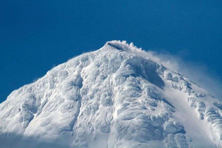 Snow and ice covered volcanic peak.