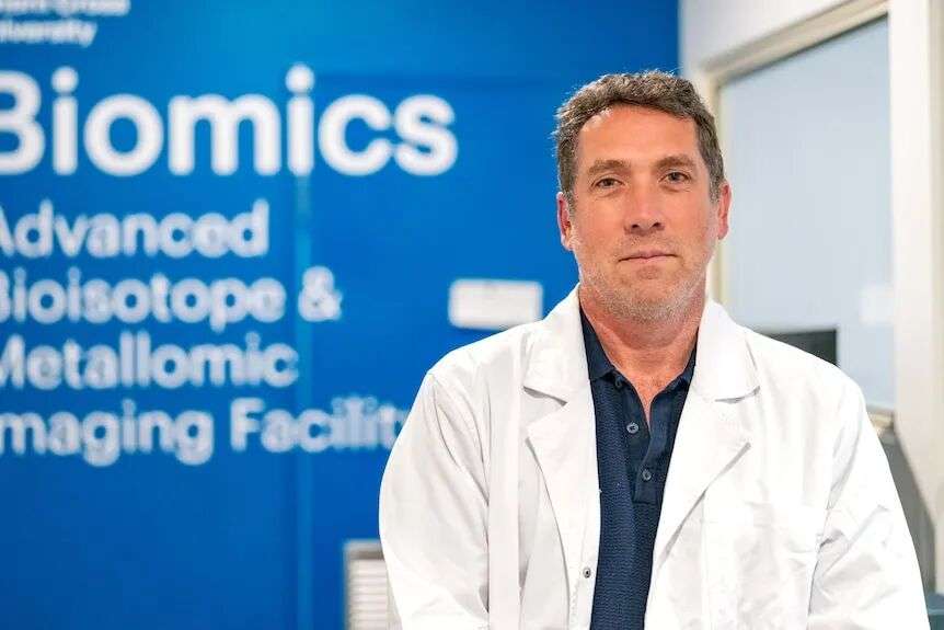 A man wears a white lab coat.