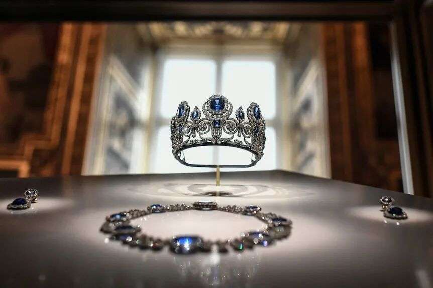 Sapphire and diamond crown at the centre, matching necklace in the foreground.