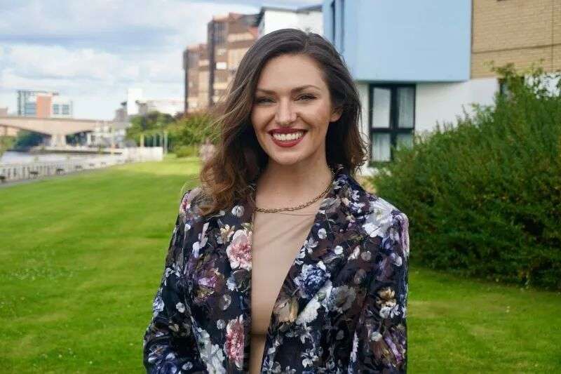 Dr Amy Perkins wearing a floral blazer and standing outside smiling