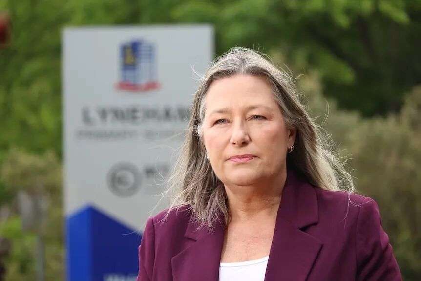 A woman with a maroon jacket on.