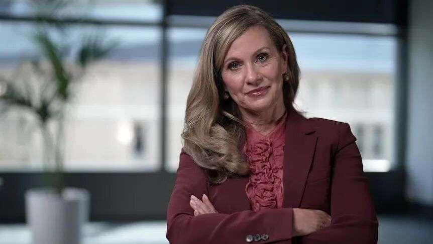 Julie Inman Grant is Australia’s eSafety Commissioner stands in her officer in front of windows with her armed crossed