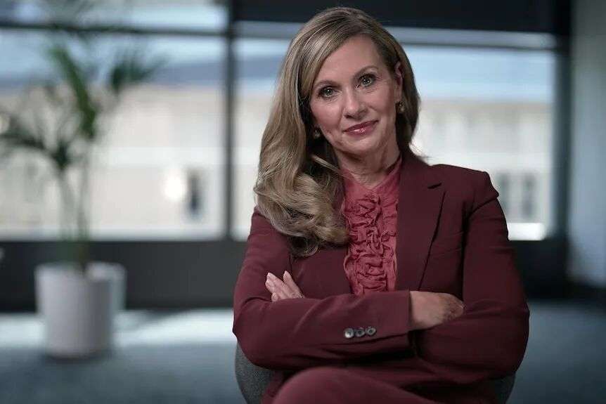 Julie Inman Grant is Australia’s eSafety Commissioner stands in her officer in front of windows with her armed crossed