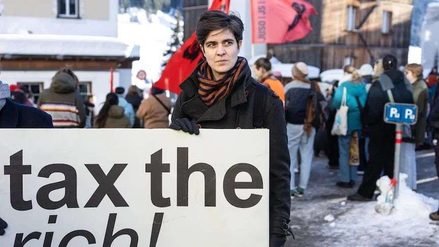 Marlene Engelhorn holds a sign that says 'tax the rich'