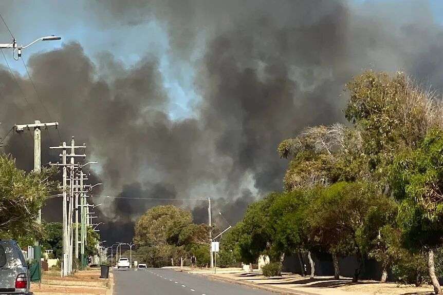 沿着郊区道路向下望去，可以看到滚滚黑烟升腾而起。