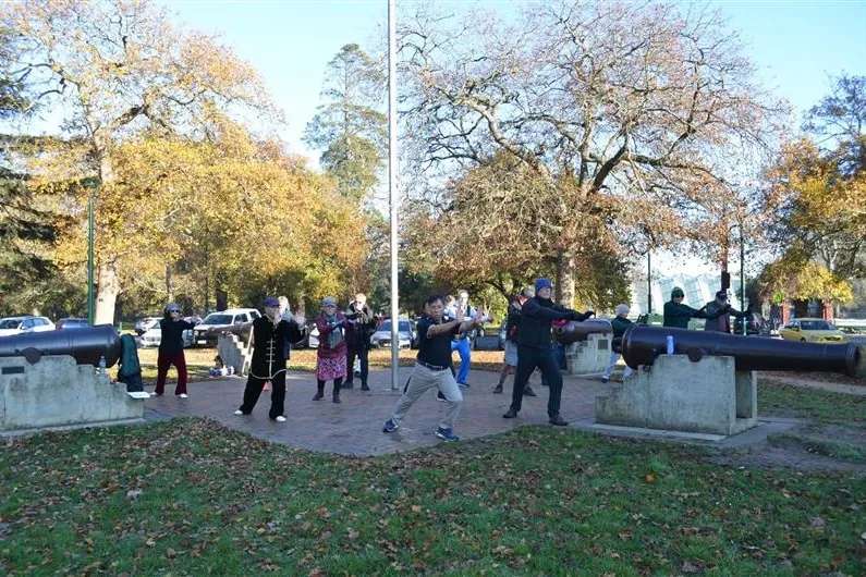 People doing tai chi in a park.
