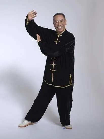 Man in tai chi uniform doing tai chi moves.
