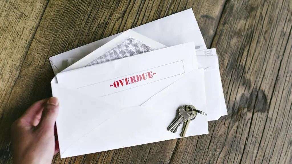 Overdue Notiice in an Open Envelope with Keys on a Wood Table - Hands of a Woman Holding - Late Bills - Rent - Mortgage