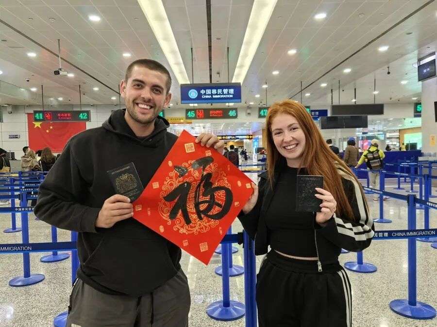 大年初一凌晨时分,英国旅客Dawson和女友Kaye成为免签新政首批受益者。(王艺璇 摄)