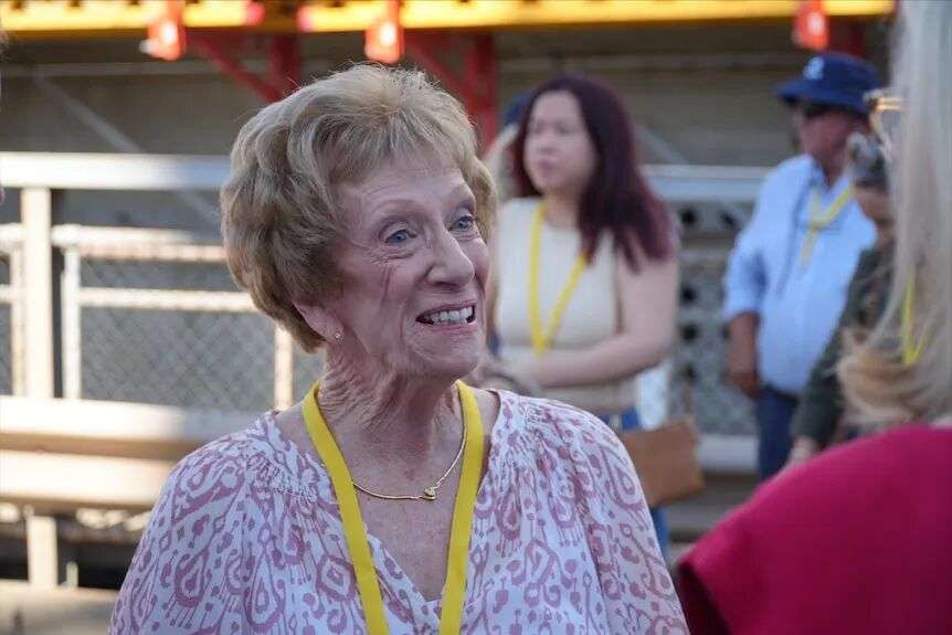 A woman in her late 80s, with short hair, smiling